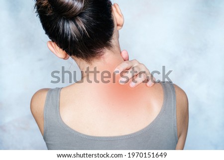 A woman massages her shoulder and neck pain points, trigger point massage, physiotherapy and massage concept Royalty-Free Stock Photo #1970151649
