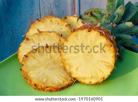 closeup of juicy ripe pineapple (ananas comosus) with sliced pieces. 