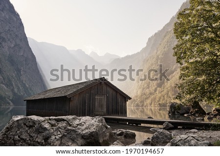 Traditional wooden boat house at lake Obersee in Berchtesgadener Land on a sunny summer morning. Schoenau am Koenigssee, Bavaria, Germany. Royalty-Free Stock Photo #1970194657