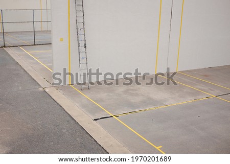 Empty grey concrete outdoor squash court with yellow lines