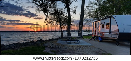 Travel trailer camping at sunset by the Mississippi river in Illinois at sunset panorama Royalty-Free Stock Photo #1970212735