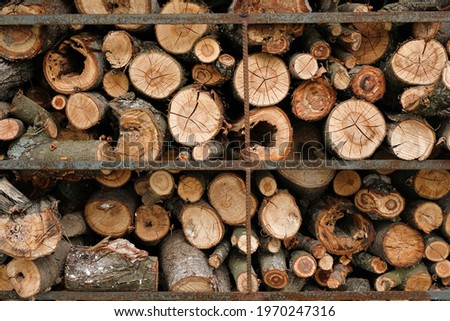 A stack of dry chopped old firewood. Pile of stacked firewood prepared for home heating