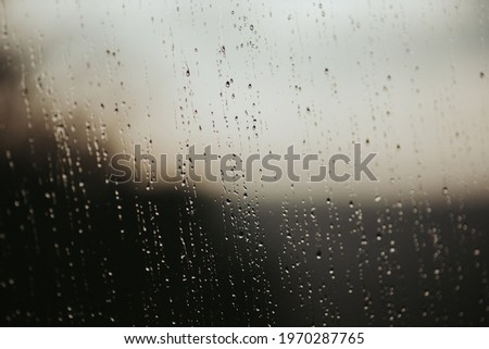 A closeup shot of a glass surface covered in raindrops