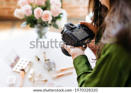 Female photographer shooting beauty products on the table Royalty-Free Stock Photo #1970328320