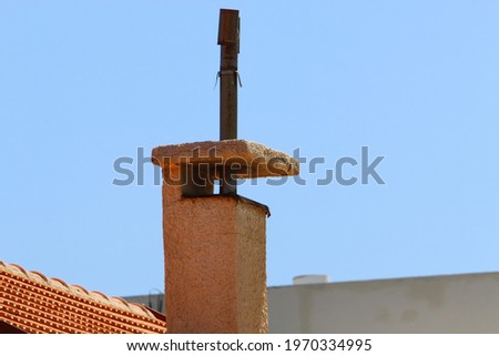 high chimney to enhance draft in the firebox against a blue sky
