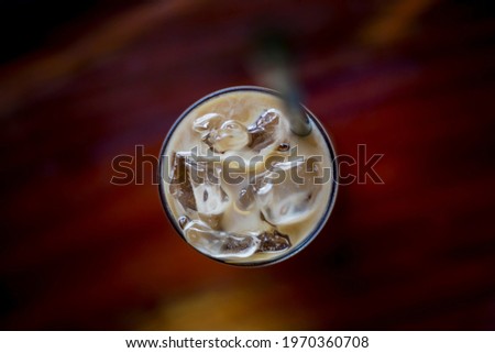 Glass of ice with condensed milk, coffee, high angle view, focus in the center of the picture