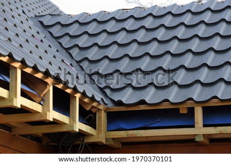 Roof construction site. Metal roof with water drops after rain. Metal roofing