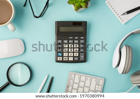 Top view photo of calculator in the middle notepad pens plant glasses cup magnifier headphones mouse and keyboard on isolated pastel blue background