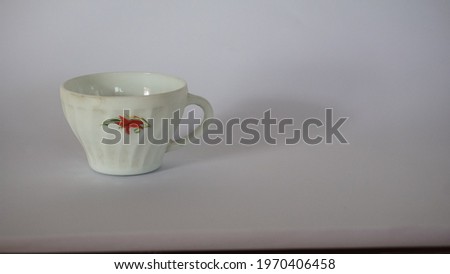 Charming white cup on white paper background