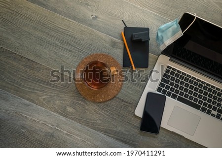 Notebook, action cam, laptop, smart phone and cup of tea on wooden desktop. Recording equipment and shooting video for vlogger and podcasters. Home working, content creators and technology concept.