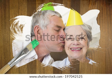 Composite image of senior couple celebrating birthday with paintbrush dipped in green against wooden surface with planks