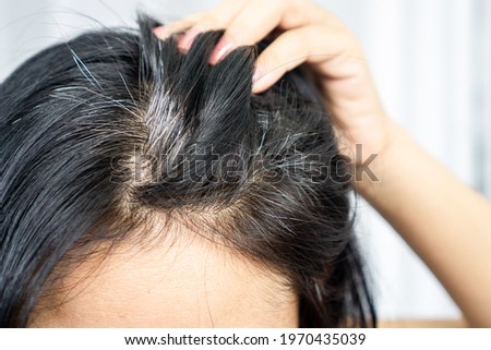 closeup Asian woman having problem with grey, white hair growing up  Royalty-Free Stock Photo #1970435039