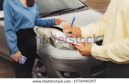 Car insurance claim concept : The victim of a female driver in a traffic accident on a road was describing the scene to an auto insurance agent to properly claim the damage according to the agreement. Royalty-Free Stock Photo #1970440397
