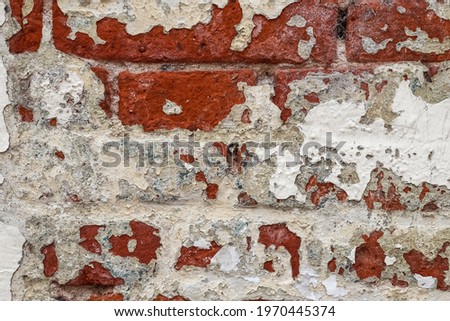 Old vintage weathered brick wall with peeling paint