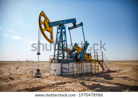 Oil pumping jack on desert sands. Zhanaozen, Kazakhstan.