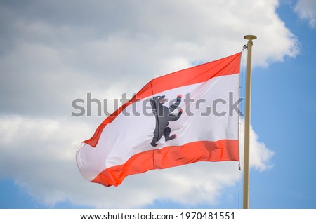 Berlin flag waving in the wind. Flag of German state Berlin flying on a flagpole. Black bear against white background. Three stripes of red-white-red. Landesflagge. Flag of West Berlin
