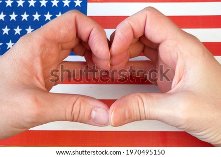 I love USA. Hands make heart pn American flag background. For 4th of July American Independence day, closeup