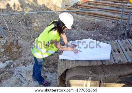 a photo of a young woman architect on the building site of the construction project