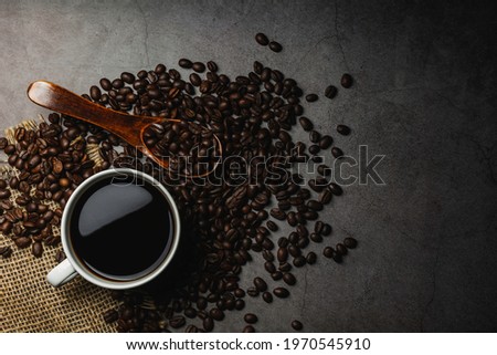 Concrete table desk with coffee. Coffee beans and coffee cup on concrete background with copy space.
