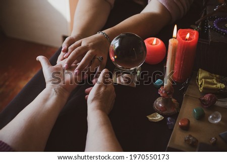  Palm rider - Seance of fortune telling on a hand, candles and fortune-telling witch objects. The concept of divination, astrology and esotericism Royalty-Free Stock Photo #1970550173