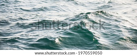 High angle view of the Mediterranean sea. Waves, splashes, water surface texture. Blue, azure, turquoise colors. Abstract natural pattern, background, wallpaper. Graphic resources, copy space