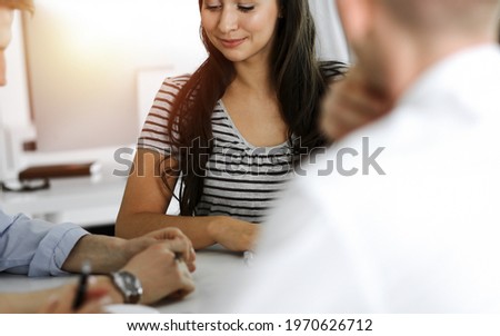 Group of business people discussing questions at meeting. Portrait of casual dressed businesswoman happy smiling to her colleagues