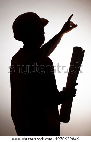 silhouette figure of young construction worker in hard hat on white isolated background showing with finger direction forward, manager responsibility
