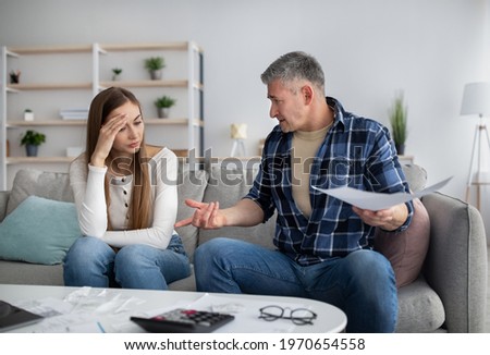 Mature couple having heated discussion about family budget, in trouble paying all bills, checking financial documents at home. Middle-aged spouses calculating income and expenses, indoors Royalty-Free Stock Photo #1970654558
