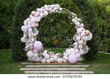Ouside wedding ceremony. Balloon wedding arch in the garden. Wedding day. Royalty-Free Stock Photo #1970659544