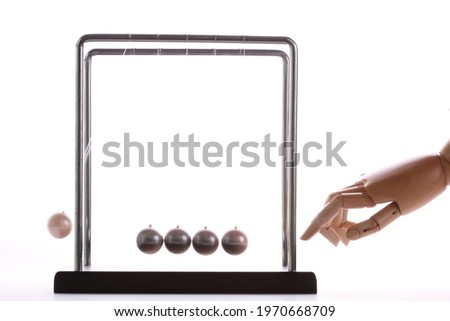 Wooden hand pushing a set of newton balls, time concept, studio photography