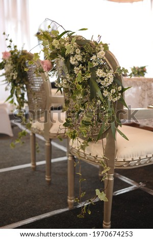 The flower decoration attached to the wedding chair is simple from the back