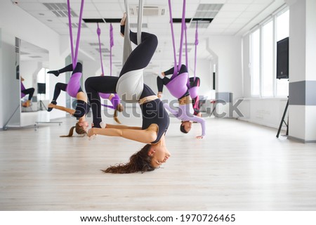 Aerial anti-gravity yoga, hanging on hammocks Royalty-Free Stock Photo #1970726465