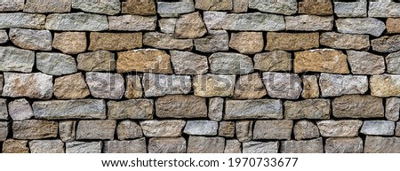 stone wall made of old and weathered cobblestones wall of an old house