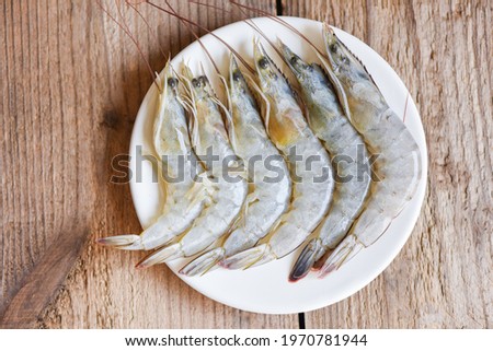 Raw shrimps prawns on white plate, Fresh shrimp seafood for cooked food - top view