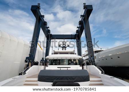 Superyacht being hauled out for shipyard period with travel lift crane with blue sky Royalty-Free Stock Photo #1970785841