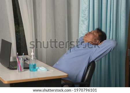 Scared or nervous! Portrait of emotional nervous young businessman in blue shirt are sitting in room working online  window background