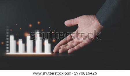 Businessman in black suit with an open hand as showing graph growth for increase. The concept of business plan graph growth