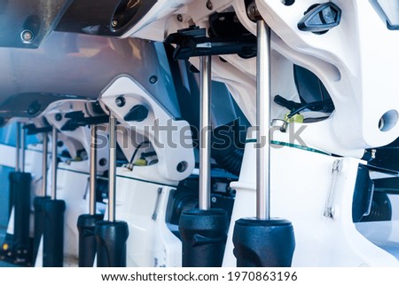 Lifting mechanisms on outboard motors at the stern of the boat. Transom lift on outboard motors of a motor boat. Royalty-Free Stock Photo #1970863196