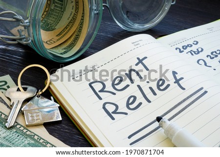 Rent relief sign and almost empty jar with money.