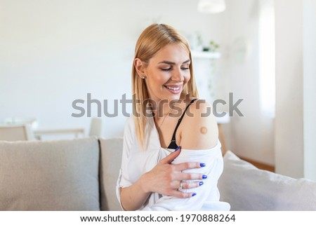 Young woman receiving getting vaccinated immunity with bandage on her upper arm, concept of innoculation, vaccination, side effects of vaccine Royalty-Free Stock Photo #1970888264