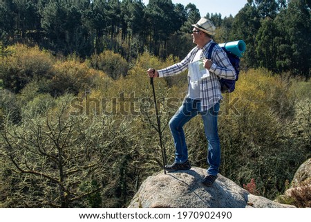 traveling man with backpack and map on top of the hill