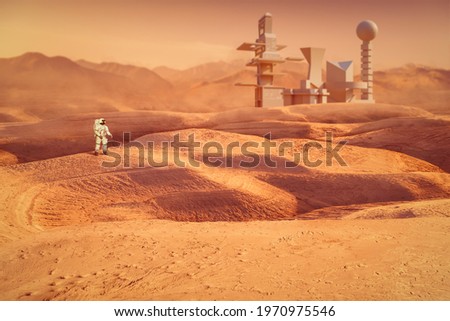 Astronaut exploring Mars planet in front of futuristic buildings. Elements of this image were furnished by NASA