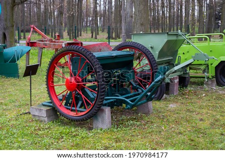 A set of old, restored agricultural machinery on the lawn in front of the museum. Picture taken on a cloudy day, soft light