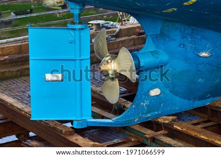 The rudder and propeller of a boat in dry dock Royalty-Free Stock Photo #1971066599