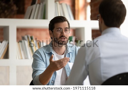 Hr manager employer asking questions to candidate on job interview, holding resume, confident business partners discussing project strategy, sharing ideas, team leader giving instructions to intern Royalty-Free Stock Photo #1971115118