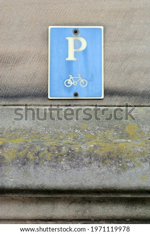 Sign for Cycle Parking on Old Stone Wall in Close Up 