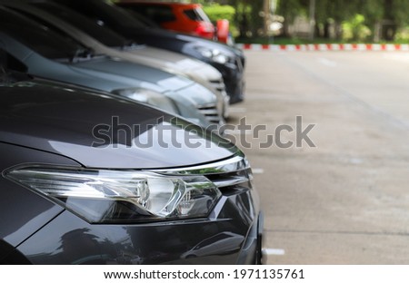 Closeup of front side of blue  car with  other cars parking in parking area with natural background.