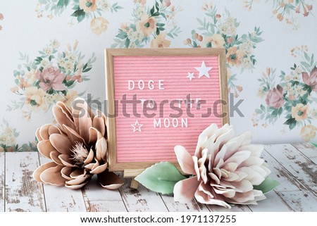 pink square felt board with wooden frame and a popular saying in the crypto currency community with flowers and floral background