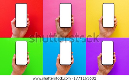 Mobile phone in hand on different multi colored backgrounds