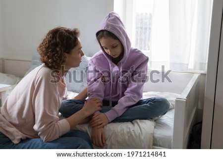 Affectionate young mommy supporting stressed sad teen child daughter. Unhappy depressed adolescent kid girl suffering from personal problems or bullying at school, sharing difficulties with mum. Royalty-Free Stock Photo #1971214841